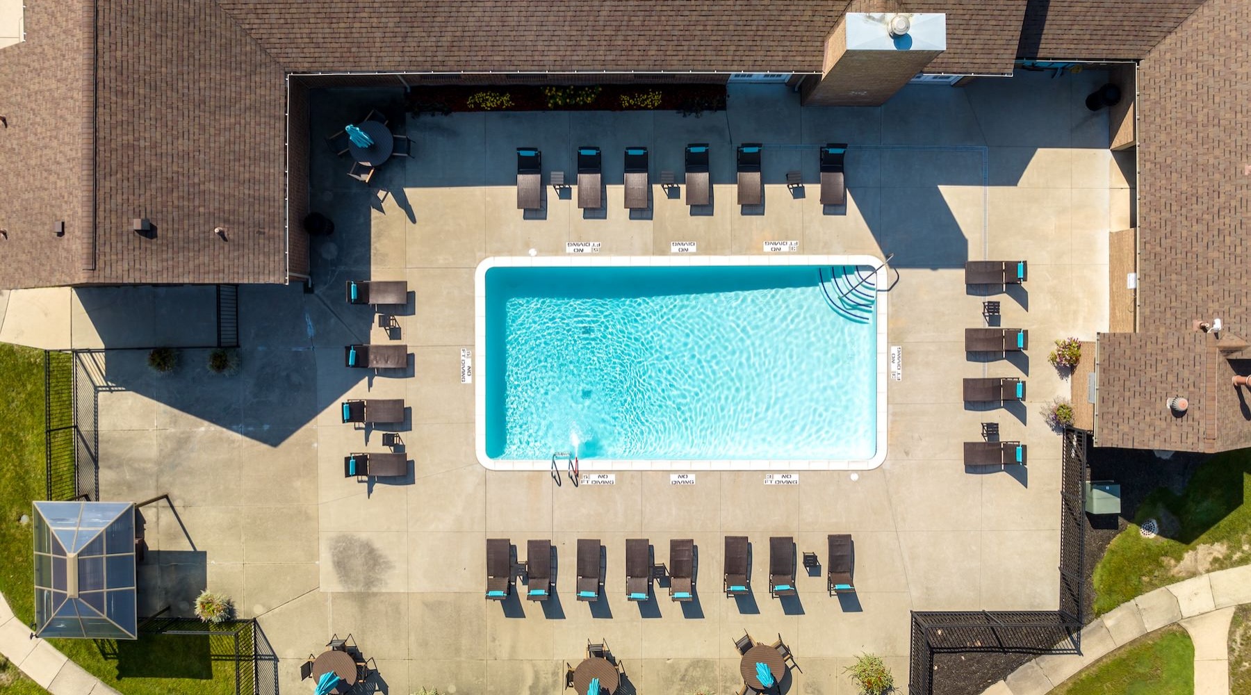 Shimmering resort style pool aerial view of a swimming pool with lounge chairs