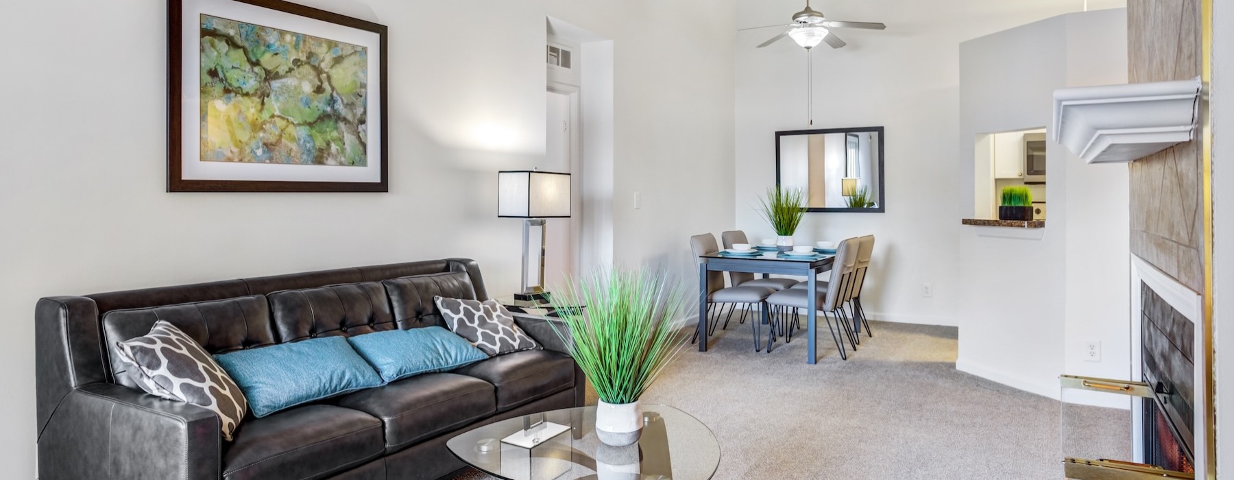 living area with a couch, coffee table and dining area in the background